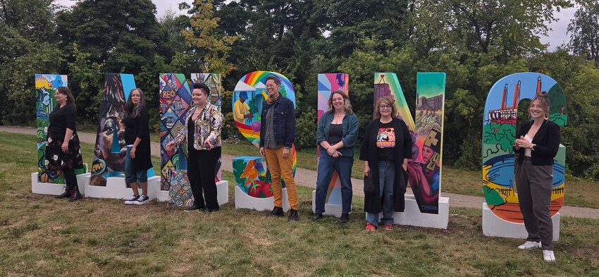 (From left) artists Emily Wilson, Teresa Dunn, Jasmyne Wells, Cait Schneider, Sara Pulver, Theresa Rosado and Marissa Tawney Thaler pose with their respective artwork.