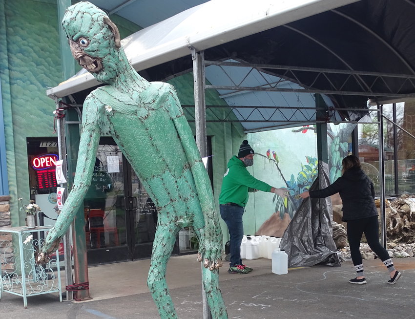 A 15-foot-tall swamp creature enforces social distancing in the parking lot of Preuss Pets, where customers are still picking up food and medicine for their furred, feathered and scaled companions.