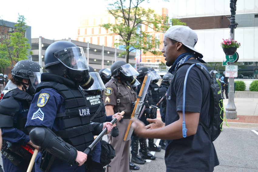A protester speaks to a police officer on Washington Square after the first round of tear gas had cleared.