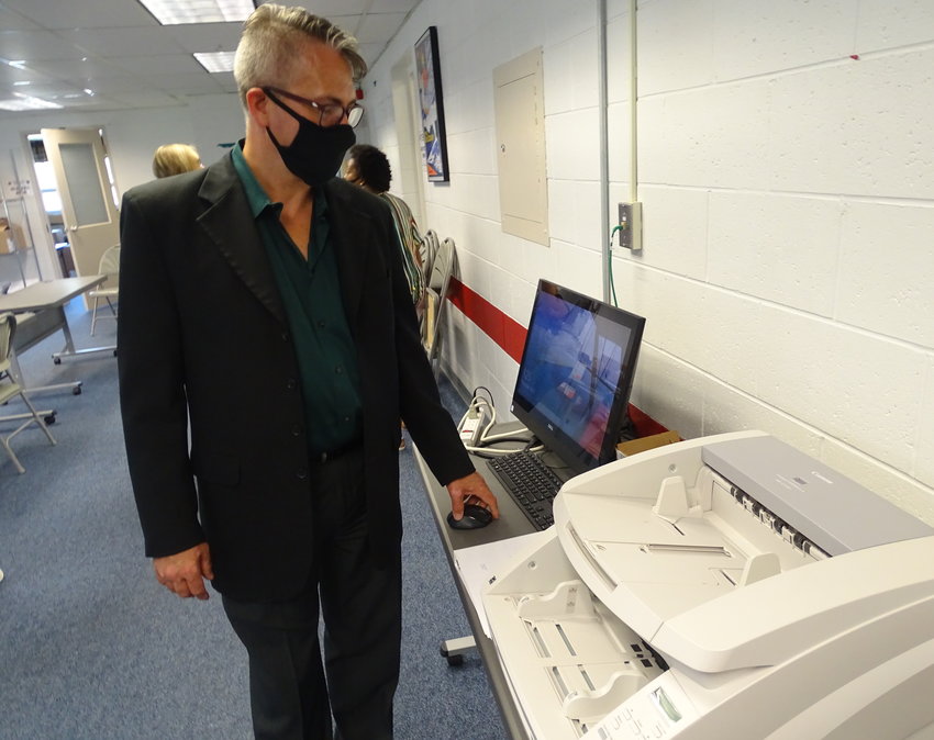 Lansing City Clerk Chris Swope communes with a scanner he&rsquo;ll use on Election Day to process absentee ballots.