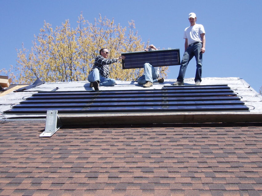 Installation of the roof-integrated solar panels on John Sarver&rsquo;s East Lansing home in 2010. These were the only panels he used until 2019 when he added additional traditional style panels.