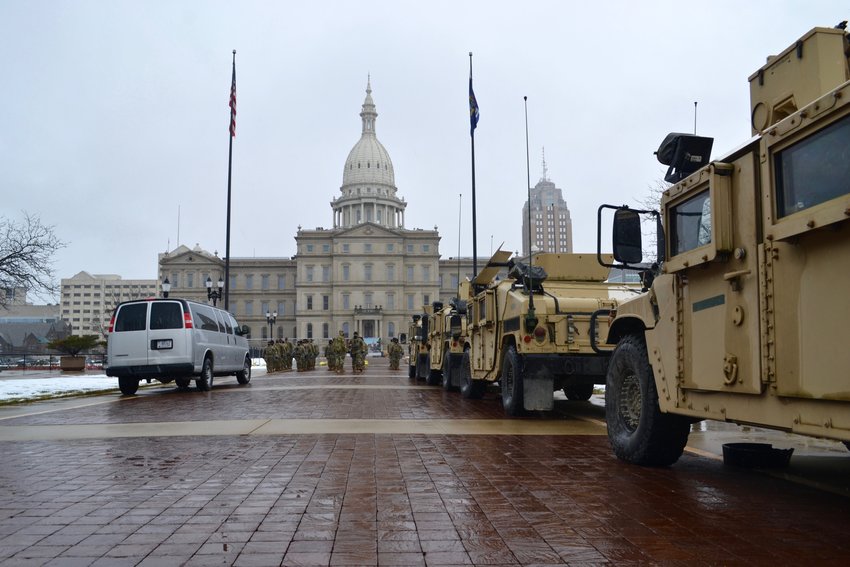 A row of National Guard vehicles lined up behind the Capitol.