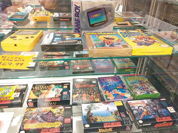 A glass case of vintage video games at Extra Levels.