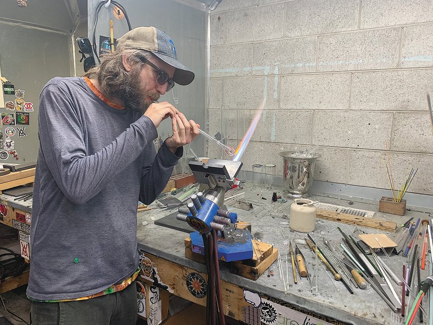 Ben Birney demonstrates a glassblowing   technique at his studio north of Lansing, which he opened about a decade ago largely out of a desire share his artwork with the local community.