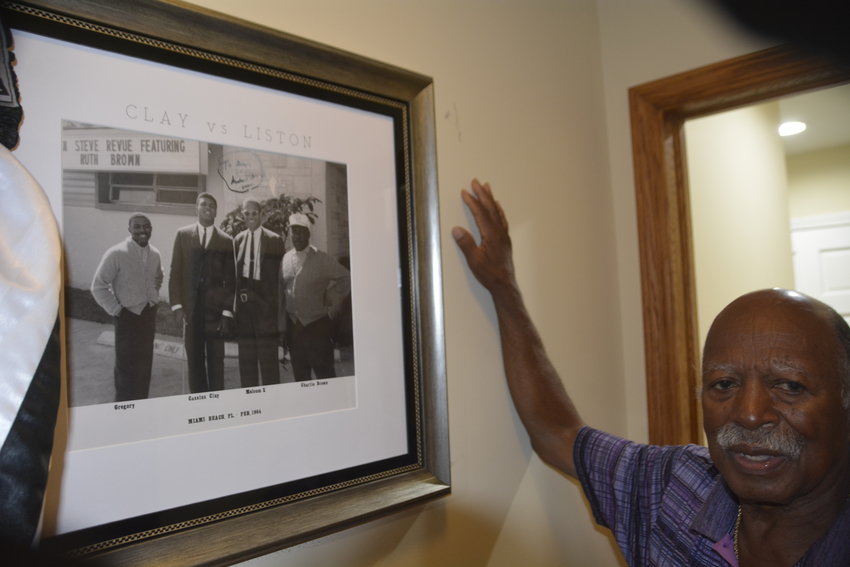Gregory Eaton with the photo of him, Muhammad Ali, Malcolm X and his uncle.