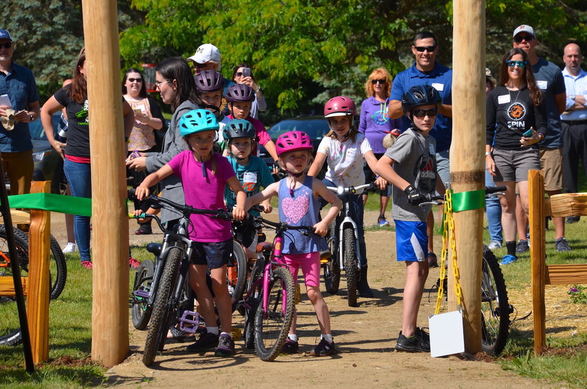Young Riders cut the ribbon and lead the first mountain bikers into Dirt School at Burchfield Park.