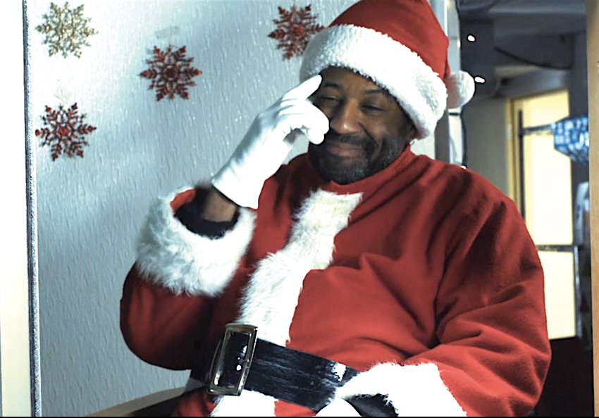 Metro Melik gives a knowing nod to a child in &ldquo;Drive-Through Santa,&rdquo; a short film by Render Studios. He&rsquo;ll play Santa in person at the Black Santa Experience, Nov. 26 at The Venue in the Lansing Mall.