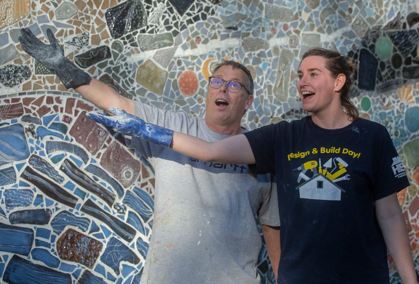 Alexandra Leonard (right) and her assistant, artist Bob Rose, in front of the mosaic mural they created on south side of the Shiawassee Street Bridge.
