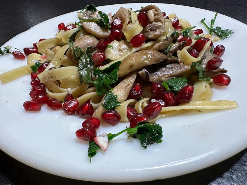 Linguine con funghi e formaggio (in English: linguini with mushrooms and cheese) is amplified by the addition of sweet, tart pomegranate seeds.