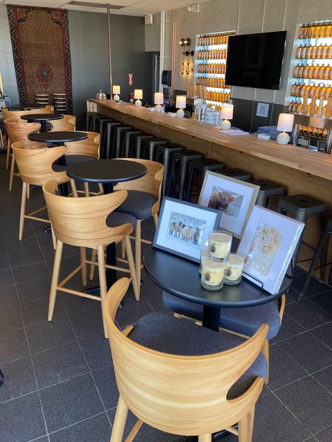 Phillips Cider Bar &amp; Market has an elegant but cozy atmosphere, with a long, wooden bar softly illuminated by the amber glow of backlit cider bottles and comfortable seating perfect for coffee dates and after-work drinks.