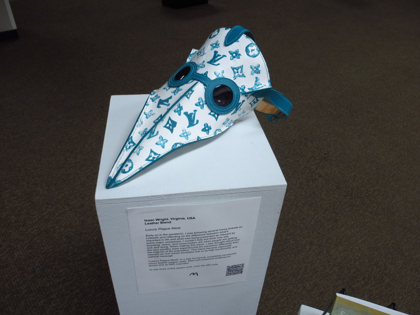 Despite the heavy subject matter, the art featured in the exhibit is not all doom and gloom. A hand-painted plague mask with Louis Vuitton branding and an N95 respirator is one piece that offers levity.