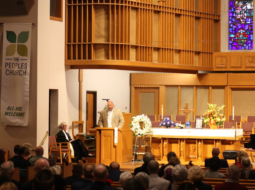 Tony Beachler, one of Ken Beachler&rsquo;s nine nieces and nephews, speaks Saturday at a memorial service at People&rsquo;s Church in East Lansing. Seated at left is the Rev. Shawnthea Monroe, one of the church&rsquo;s pastors.