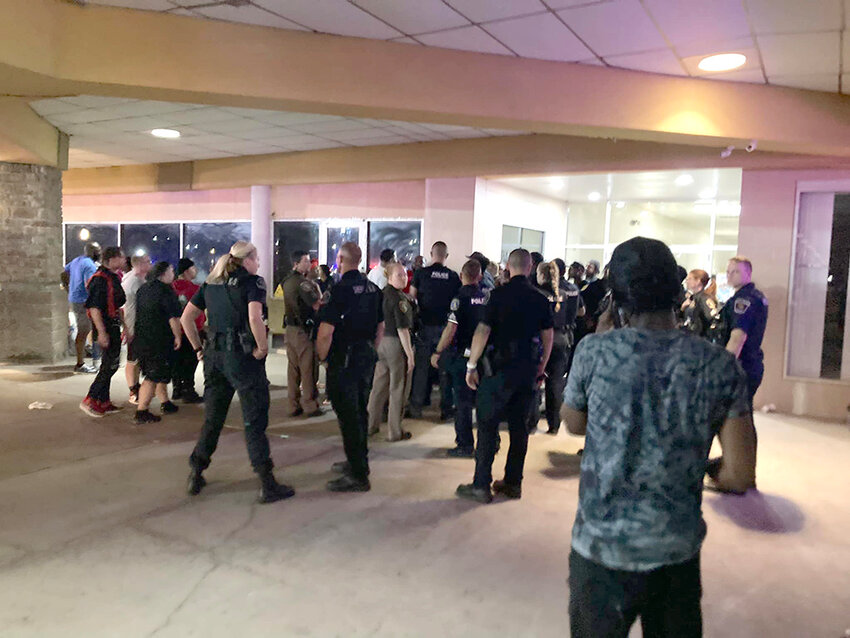 Law enforcement and patrons from a concert gather in an open-air hallway in Logan Square Shopping Center following a 1 a.m. shooting that left five people injured on Sunday (July 30).