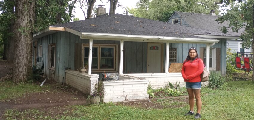 Tabitha Castilla outside the red-tagged house on Stafford Street in south Lansing that she wants to make a home for her family. Because of a technicality, she cannot qualify for loans to fix it up.