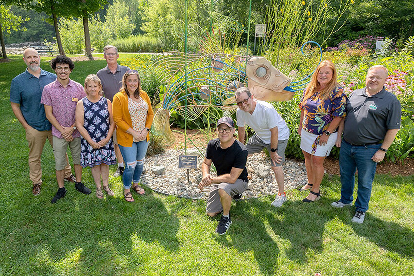 (From left) Dimondale Arts Commission chair Camron Gnass; Eaton County Commissioner Jacob Toomey; Village trustees Lori Conarton, Bill Bower and Andrea Tardino; artist Richard Tanner, commission members Scott Pohl and Sharon Novasel; and Village Manager Denis Prisk pose with Dimondale&rsquo;s second publicly funded sculpture, Tanner&rsquo;s &ldquo;The River (Runs Through Us)&rdquo;.