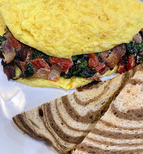 Square One Breakfast & Bakery’s West Side omelet is loaded with spinach, roasted red peppers, green onion, herbed cream cheese and bacon.