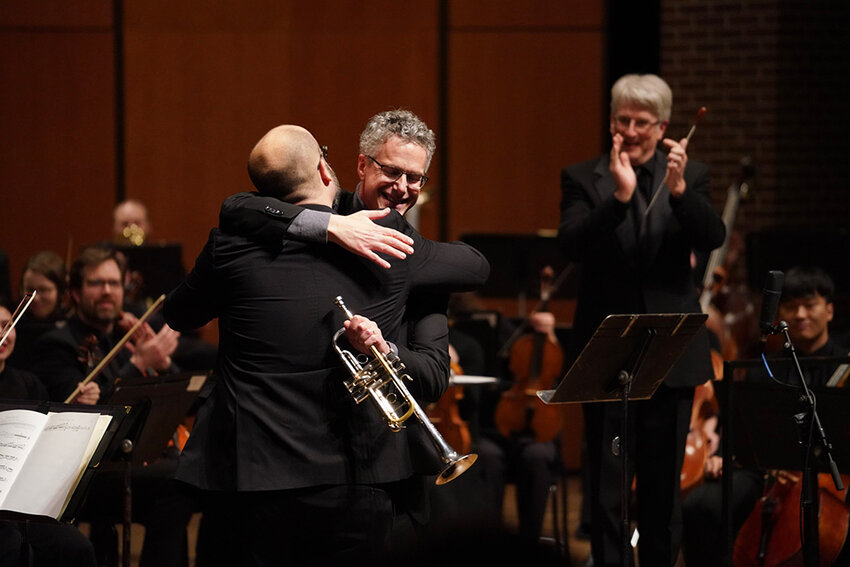 LSO principal trumpeter Neil Mueller and MSU composer David Biedenbender shared a friendly embrace following the symphony&rsquo;s world premiere of Biedenbender&rsquo;s new trumpet concerto, &ldquo;River of Time.&rdquo;