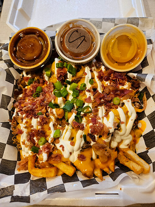 Loaded fries from the Smoke N’ Pig BBQ, brimming with cheesy and meaty goodness.