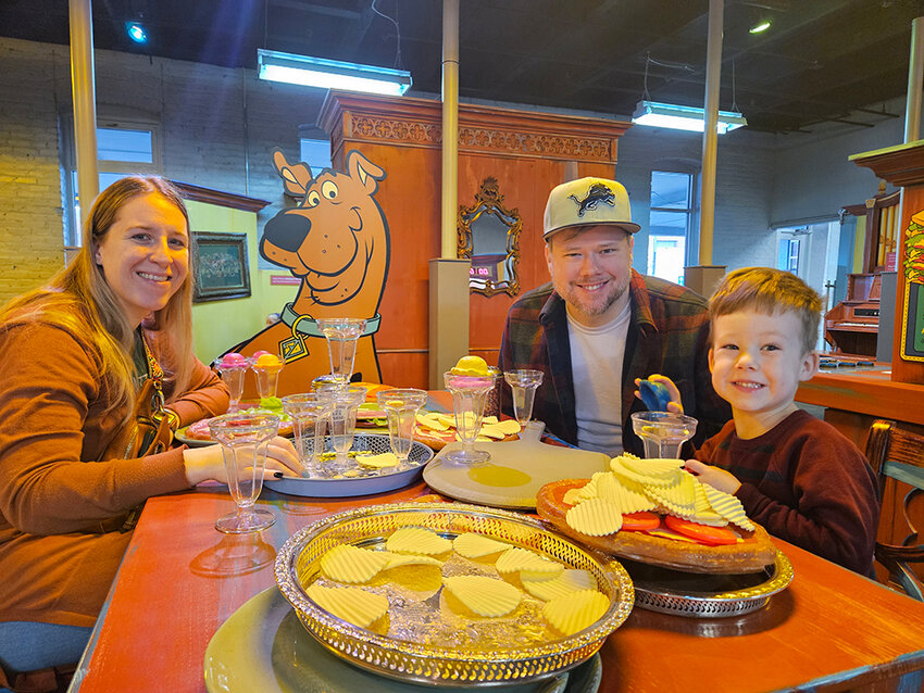 From left: Jillian, Dan and Harry Adams enjoy a meal with Scooby-Doo at the &ldquo;Scooby-Doo! Mansion Mayhem&rdquo; exhibit, which opened Saturday (Jan. 27) at Impression 5 Science Center.