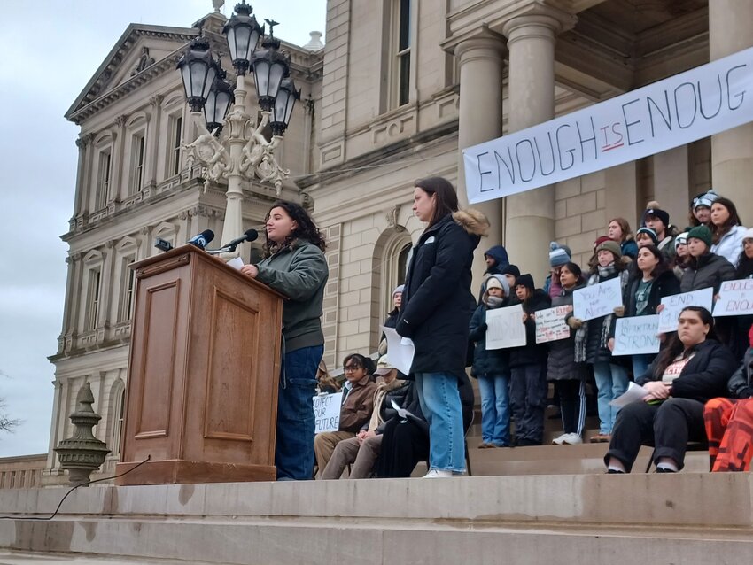 MSU student-activists Maya Manuel (left) of Sit Down MSU and Saylor Reinders of Students Demand Action lead a rally today against gun violence from the steps of the state Capitol, just over one year following the deadly campus shooting that killed three students and injured five more.