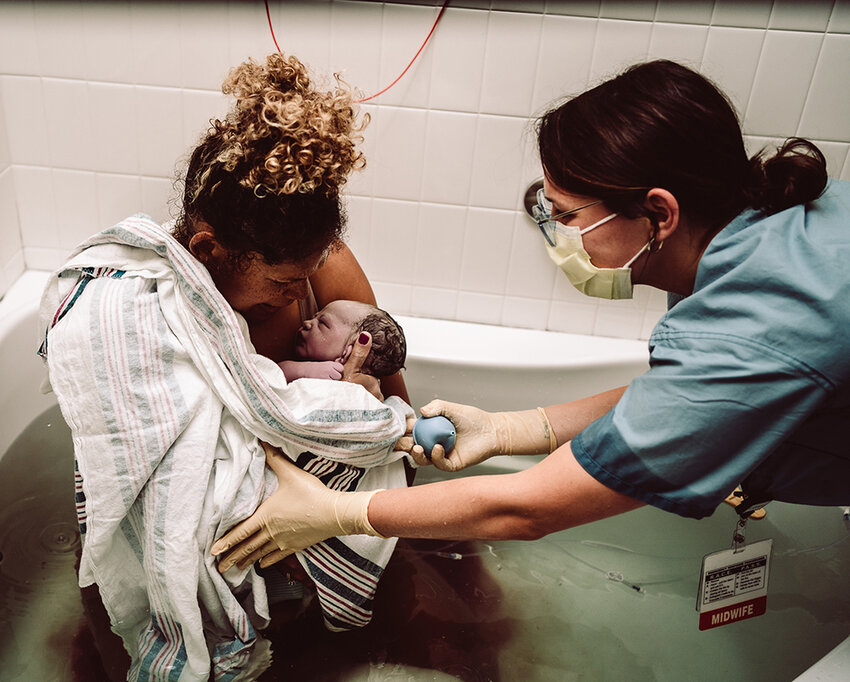 Amanda Trojan holds baby Nathanael following his water birth at Von Voigtlander Women&rsquo;s Hospital in Ann Arbor on June 25, 2022, attended by certified nurse-midwife Kayla Joy Jasman.