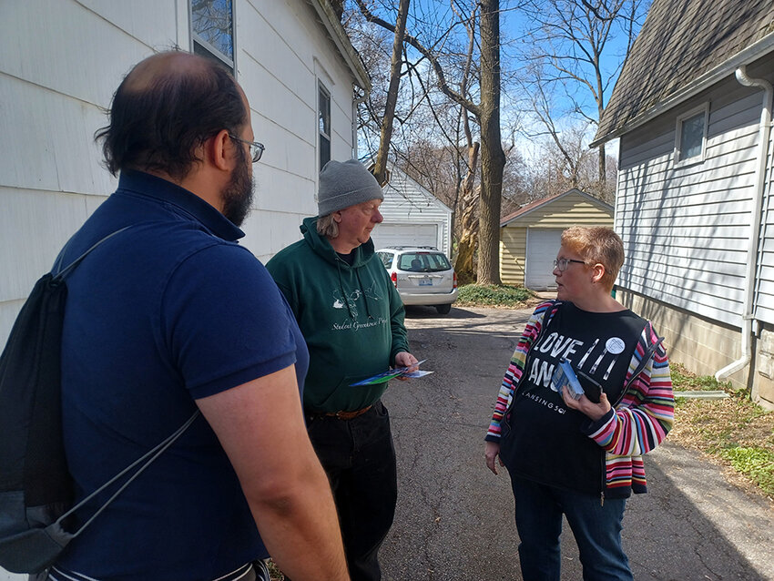 (From left) Candidate Heath Lowry, 1st Ward voter Phillip Lamoureux and candidate Julie Vandenboom discuss the upcoming Lansing Charter Revision Commission election during a door-knocking session in early April.
