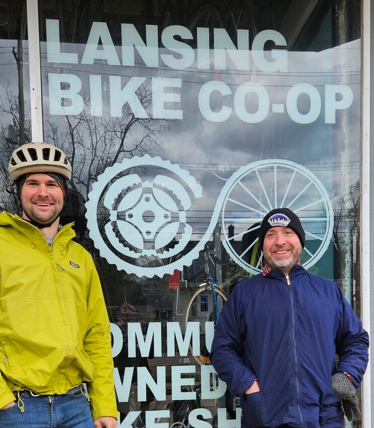 Participant Mike Dombrowski (left) and Lansing Bike Co-op executive director Aaron Fields pose in front of the co-op before its monthly alley cat scavenger hunt on April 20.