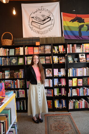 Eleanor Richards, co-owner of Wayfaring  Booksellers, poses with the shop&rsquo;s Pride  Month display.