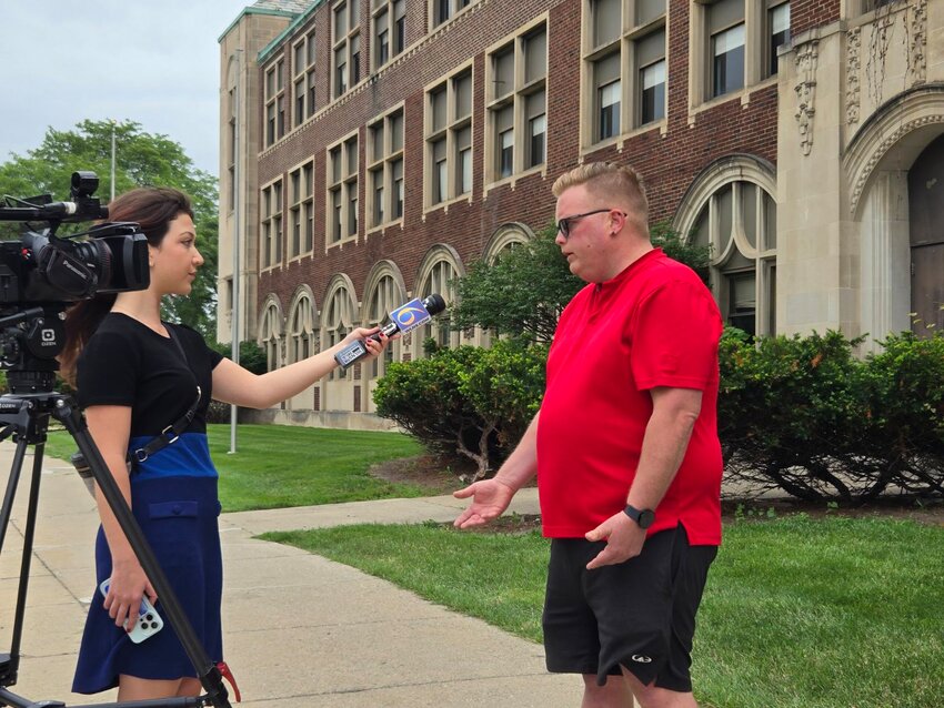 (From left) WLNS reporter Tessa Kresch interviews First Ward Councilman Ryan Kost on the movement to save the old Eastern High School from demolition.