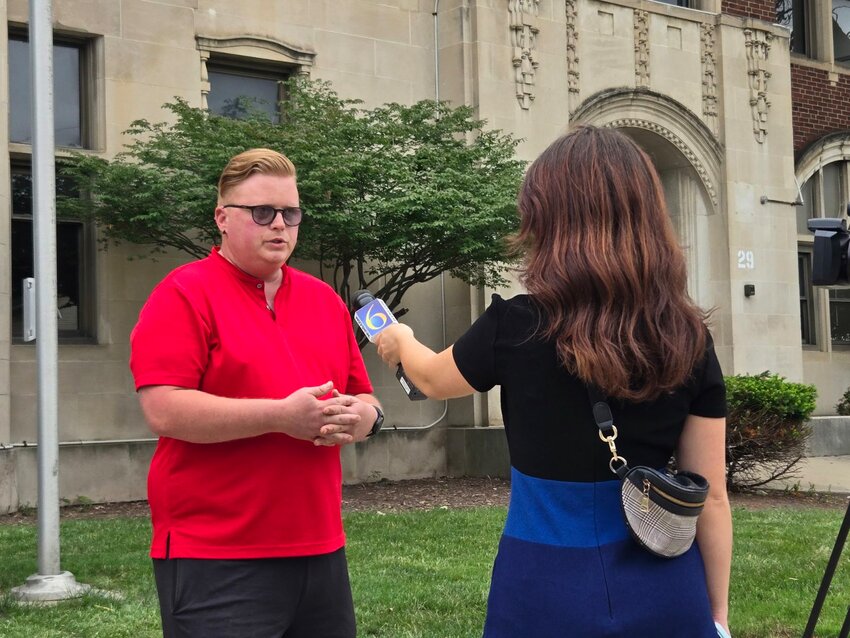 City Council member Ryan Kost making a case to a television reporter for saving old Eastern High School from demolition by the University of Michigan.