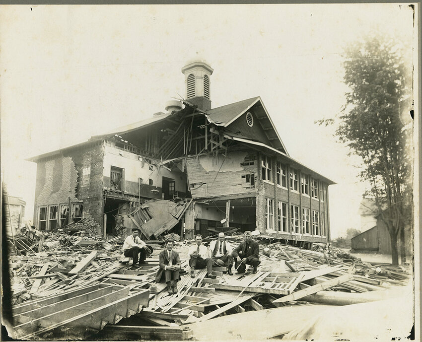 A  real photo postcard depicts the remnants of Bath Consolidated School after the Bath School disaster, in which a disgruntled local farmer and former public official set off dynamite at the school, leaving 43 dead.