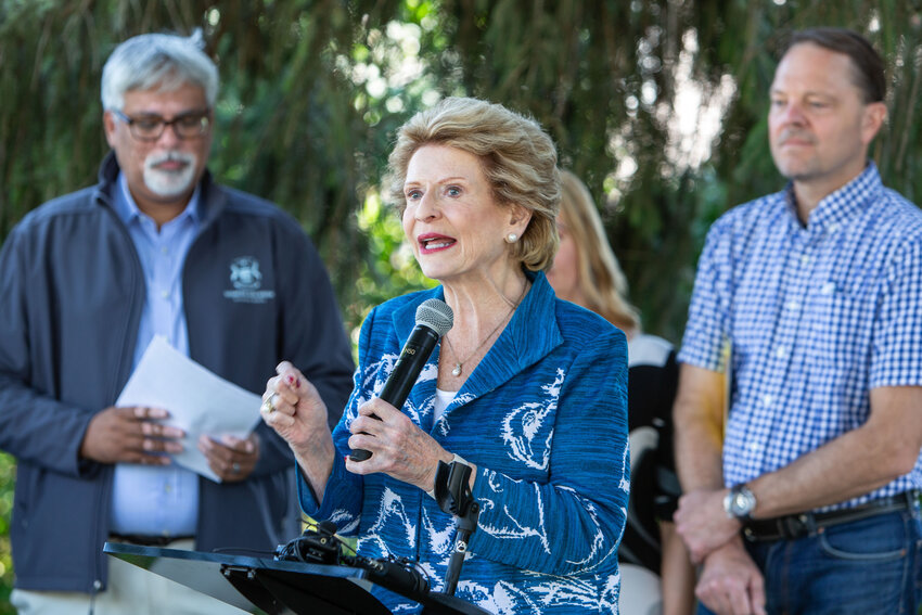 U.S. Sen. Debbie Stabenow and other local officials congregate outside the East Lansing home of Ann and George Siegle to applaud the pair's decision to use tax credits made available by the Inflation Reduction Act to install solar panels on their roof. State Sen. Sam Singh, D-East Lansing, is to the left.