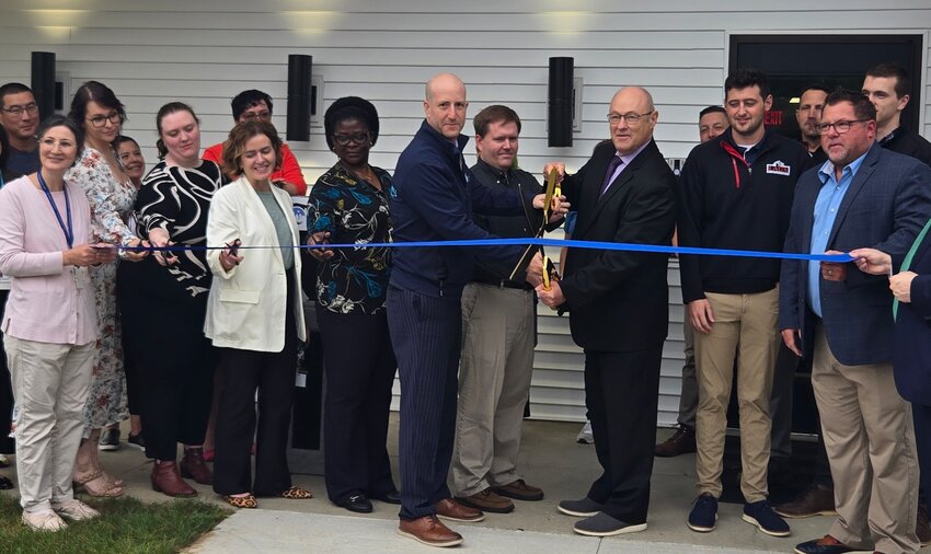 Lansing school officials prepare to cut the ribbon at the dedication of the district's new Newcomer Center for foreign-born pupils. Holding the scissors (from left) are Superintendent Ben Shuldiner, Board of Education member Dan Nowiski and Sergio Keck, deputy superintendent of special populations.