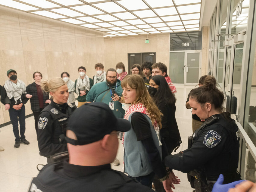 MSU police handcuff a protester, one of 19 arrested during a sit-in in the Hannah Administration Building organized by the Hurriya Coalition