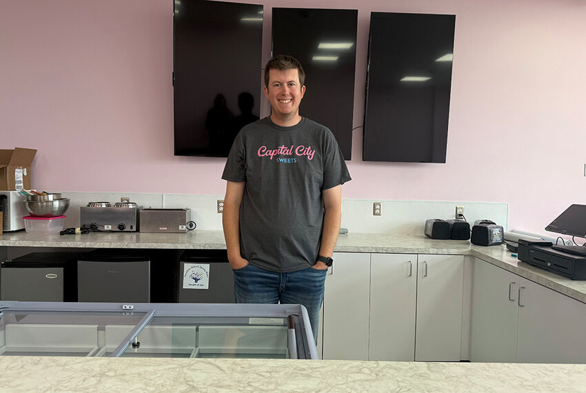 Capital City Sweets co-owner Patrick Kayser stands behind the counter of the soon-to-open standalone location on Michigan Avenue.