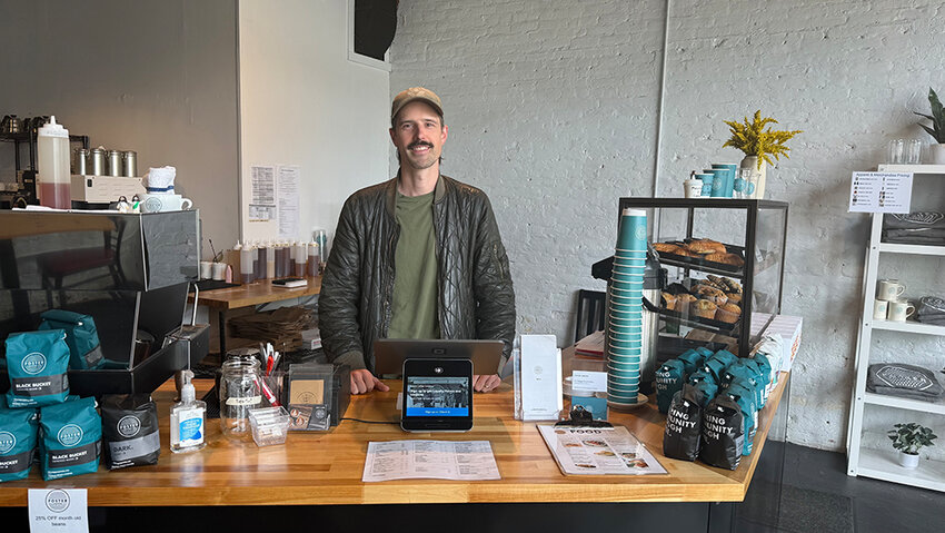Foster Coffee Co. co-owner Nicholas Pidek stands behind the counter of the business’ new Eaton Rapids location, which opened April 25 in the former BlackDog Coffee shop.