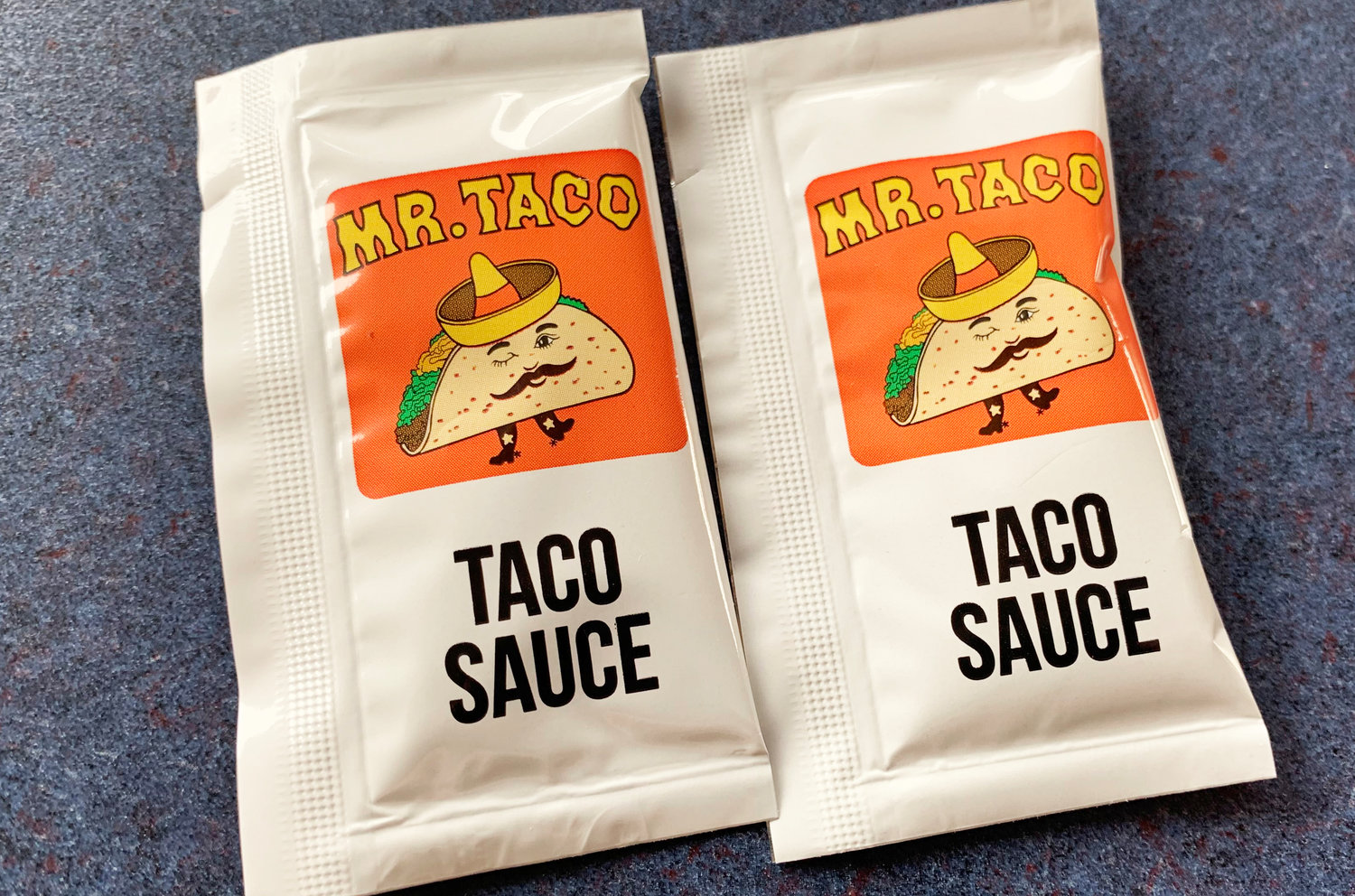 Two packets of Mr. Taco's taco sauce.