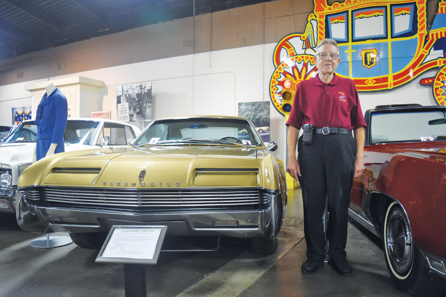 R.E. Olds Transportation Museum volunteer Jerry Garfield stands next to a 1966 Oldsmobile Toronado.
