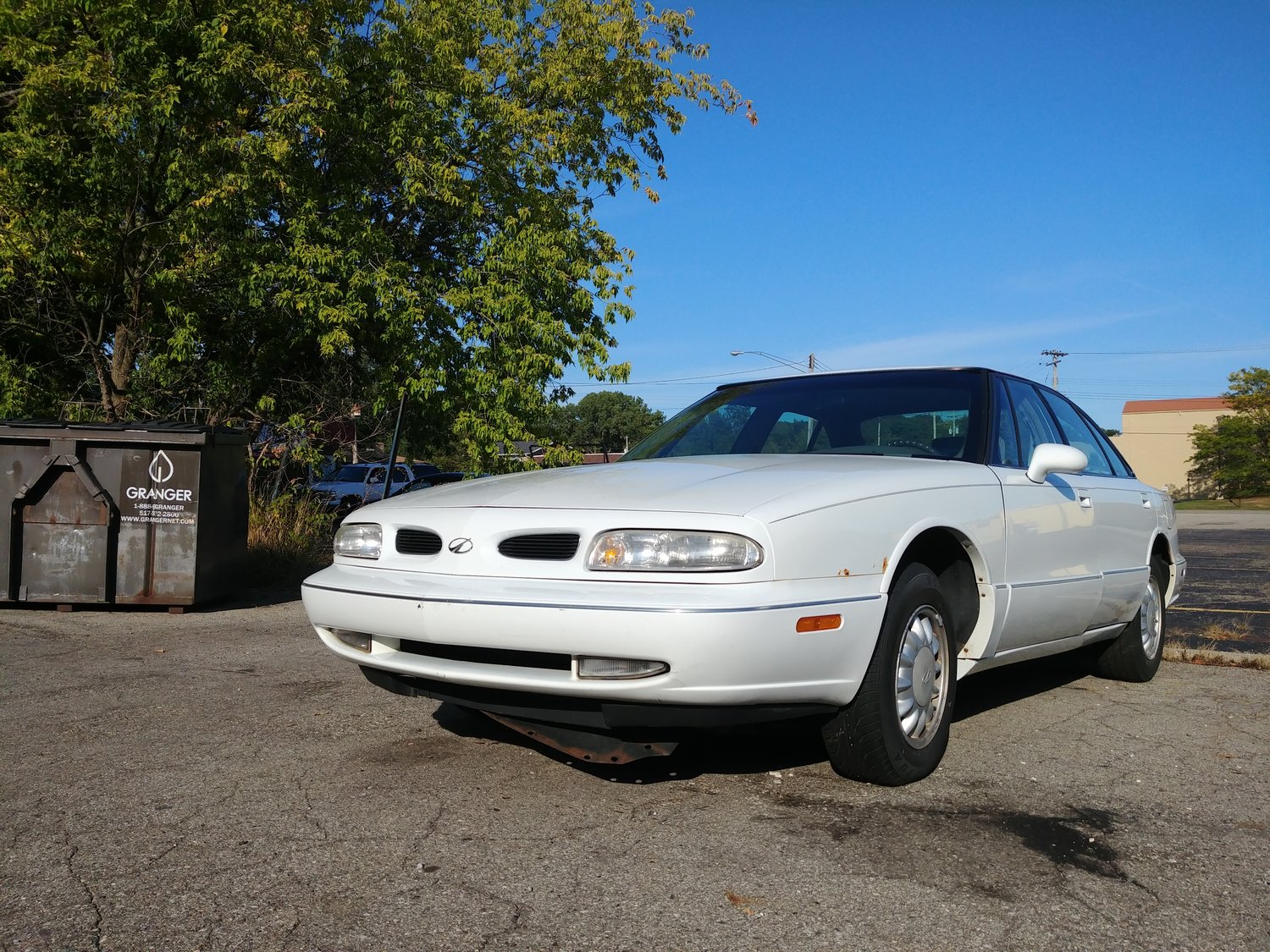 An Oldsmobile 98 with a rusted out subframe is on its last leg at a Midas repair shop in Lansing.