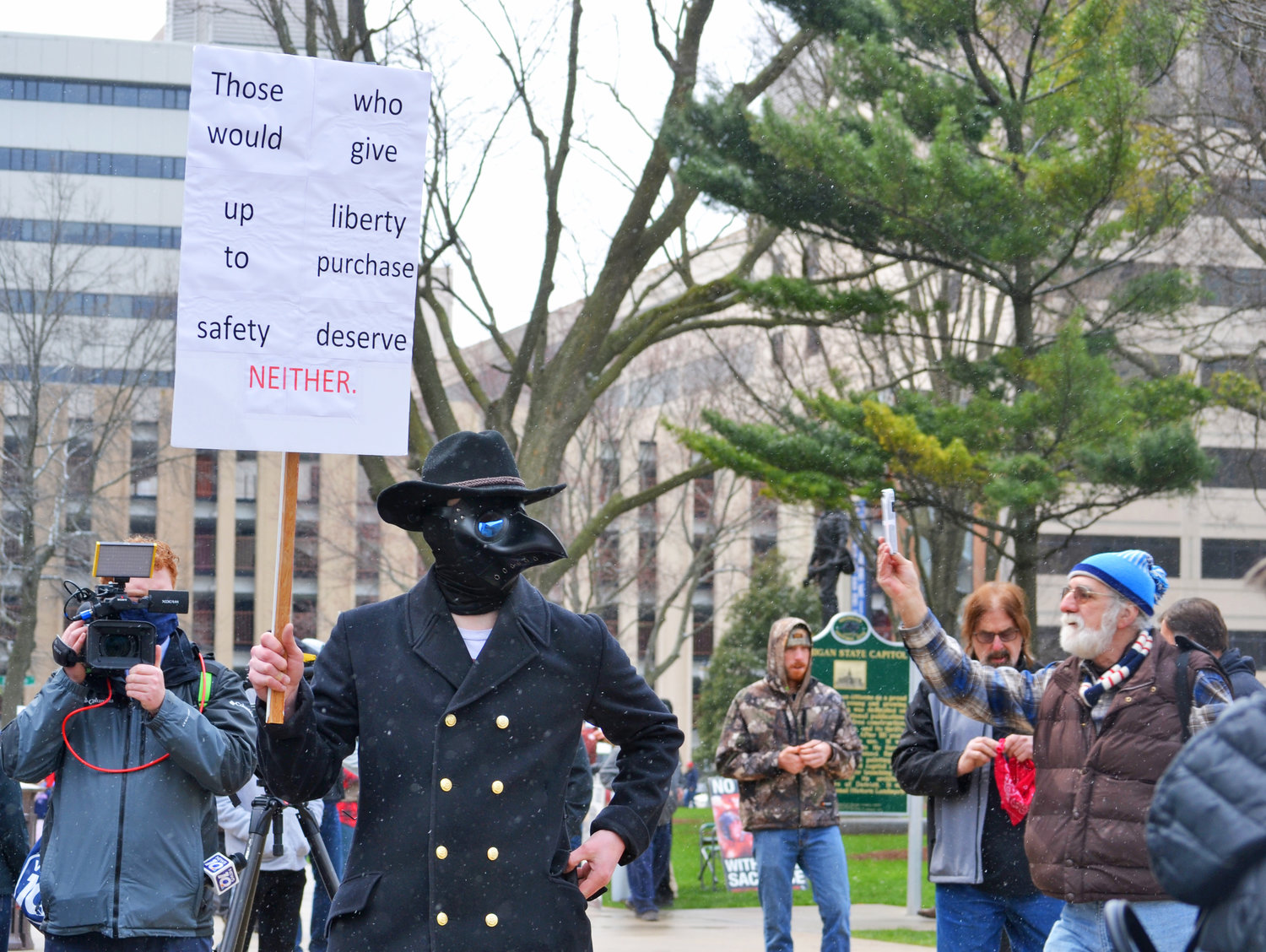 A man dons a plague doctor outfit at the protest today.