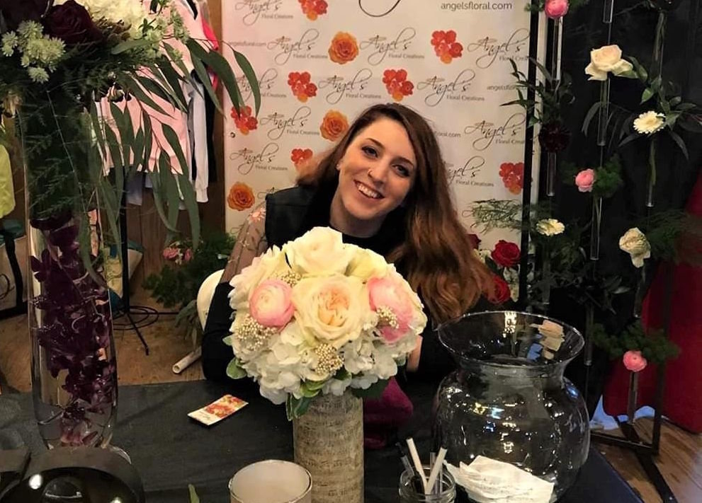 Tricia Camberlain poses with a selection of floral arrangements from Angel's Floral Creations, a flower shop founded by her mother.