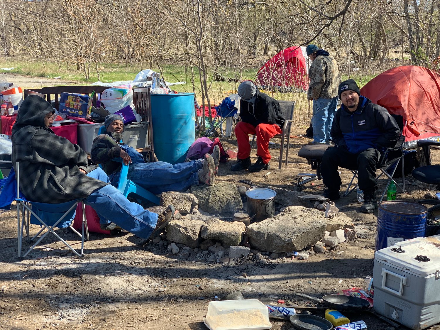A group was gathers at a makeshift homeless camp in Lansing on Monday.