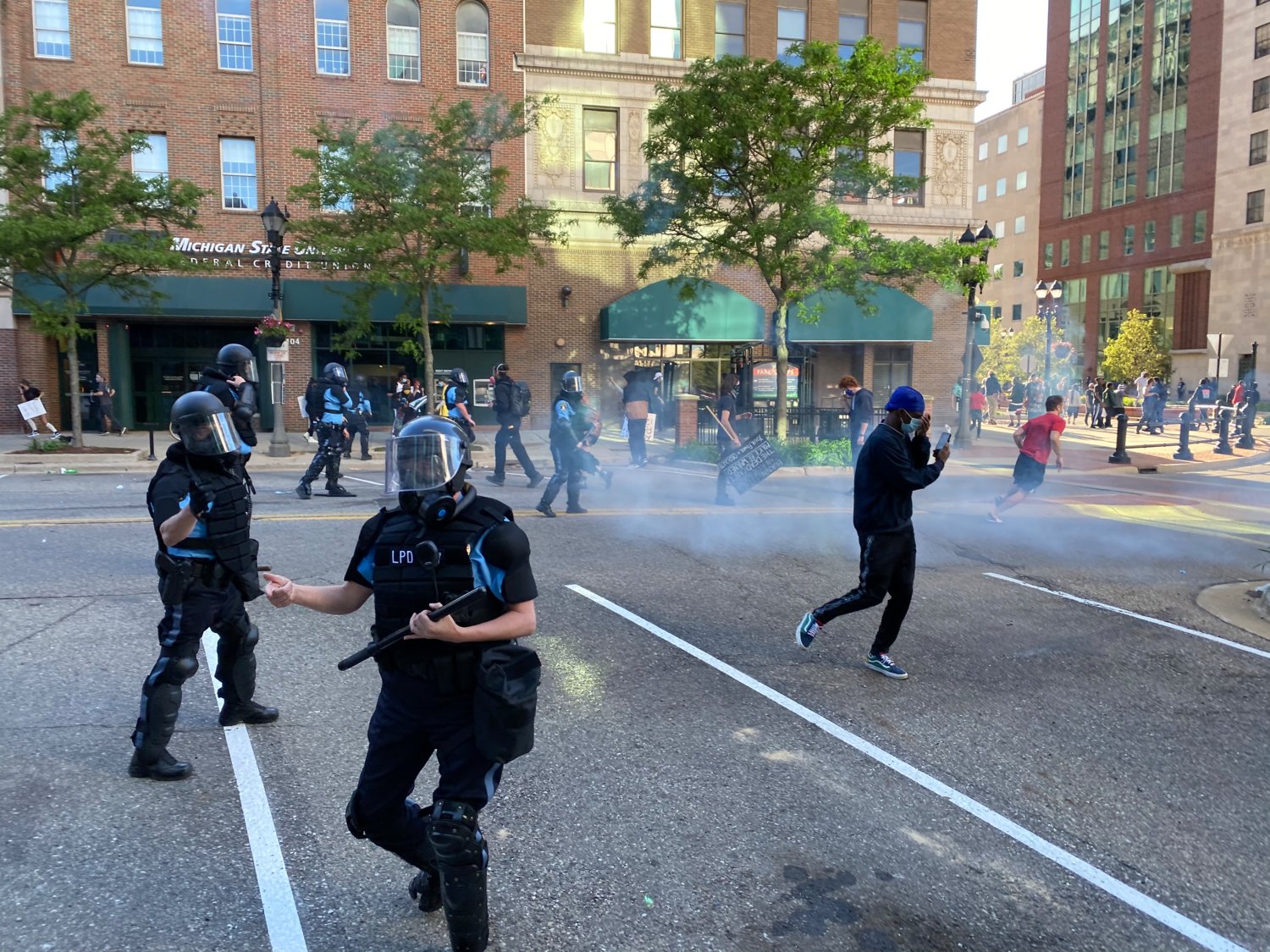 Police and protesters react to the use of tear gas on Washington Square Sunday.