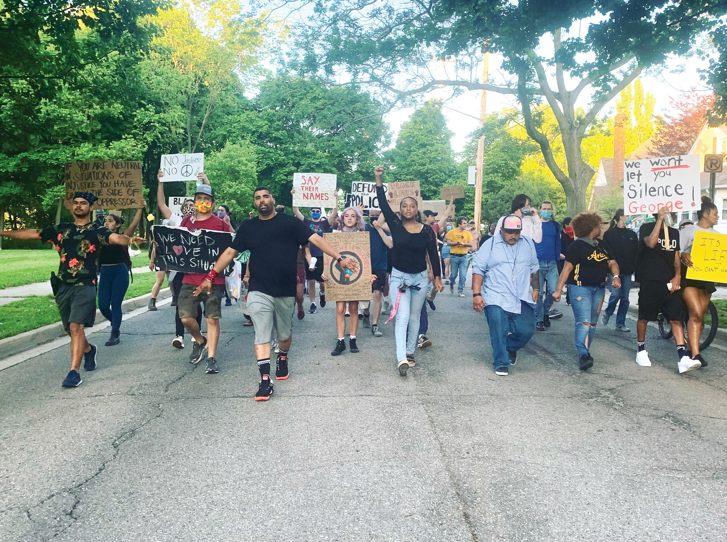 Paul Birdsong (left of center, black shirt) leads protesters in a march on Moores River Drive en route to Lansing Mayor Andy Schor's home.