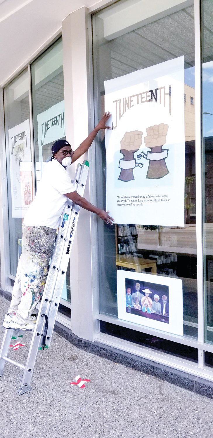 Julian Van Dyke working on his "Juneteenth: Celebrating Freedom" display at the downtown branch of Capital Area District Libraries.
