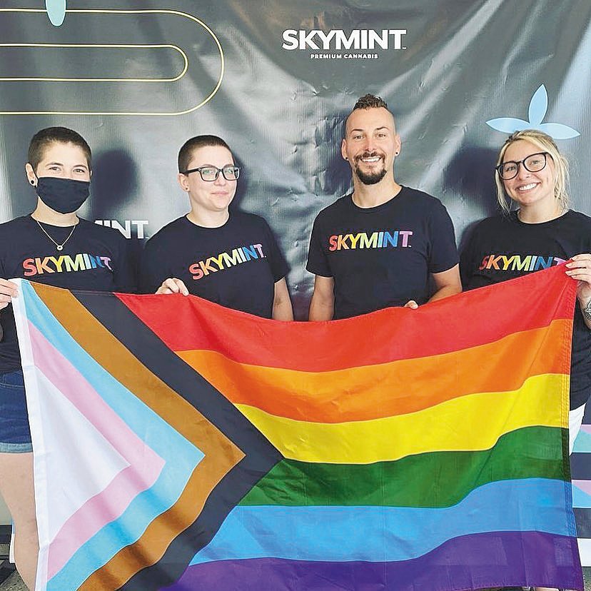 Skymint staff members holding a pride flag.