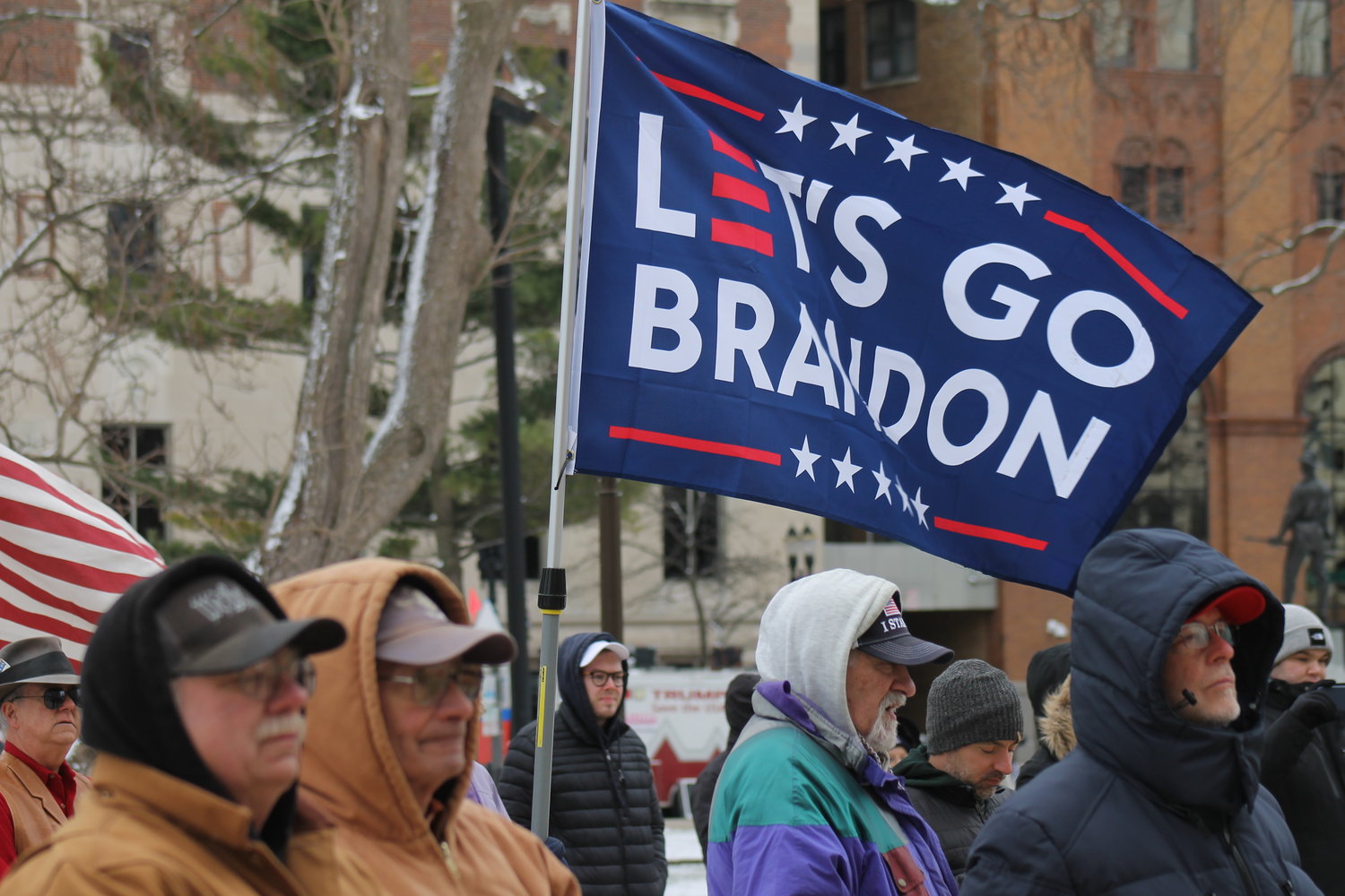 A rally goer braves freezing temperatures on Saturday (March 26) to support election conspiracies. The flag is a reference to an erroneous translation of a NASCAR chant by a commentator. The actual chant was "Fuck Joe Biden."