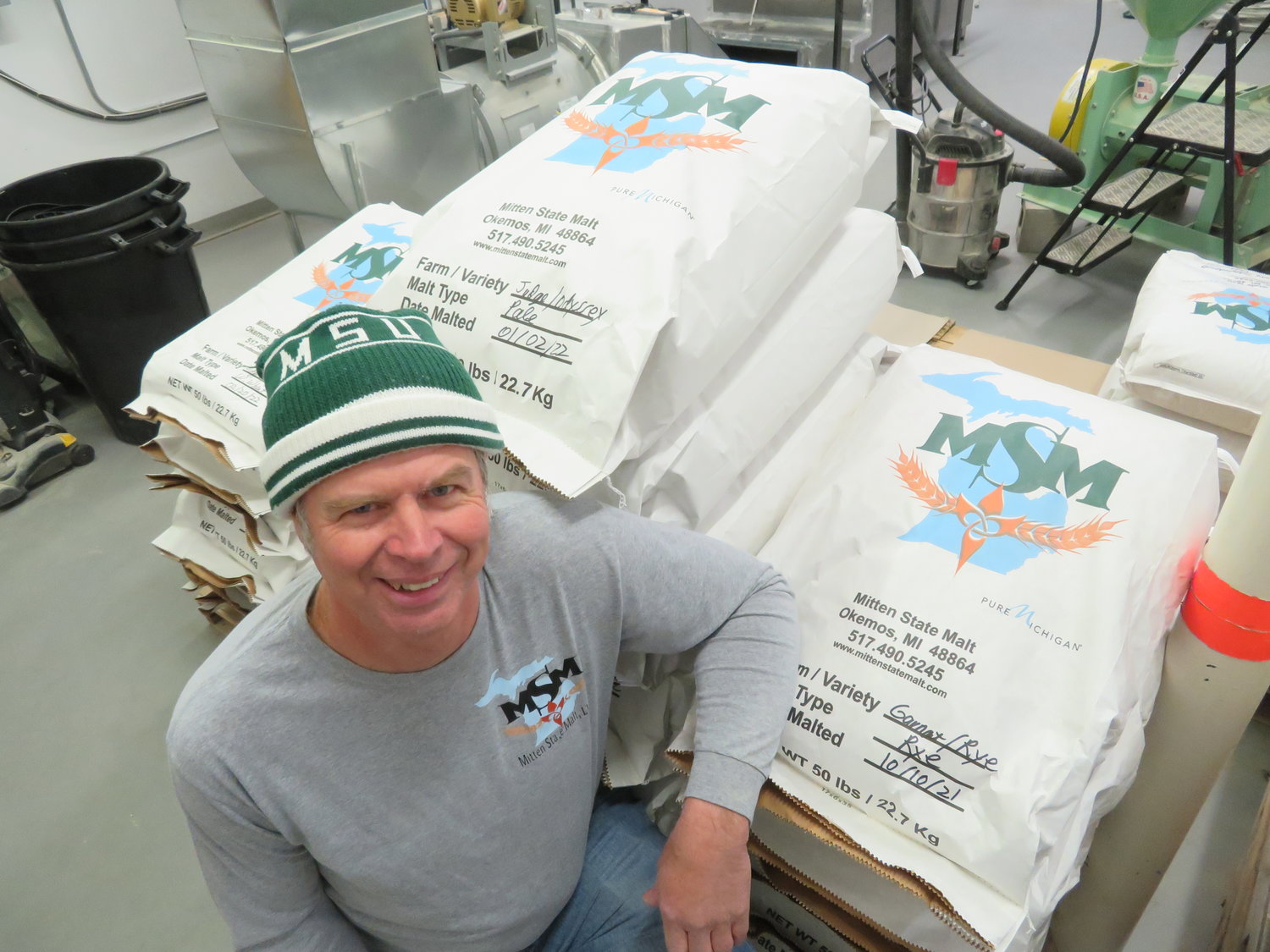 Mitten State Malt man Larry Judge huddles with a fresh batch of beer-ready malt, steeped and dried in his Okemos 
facility behind Mert’s Meats.