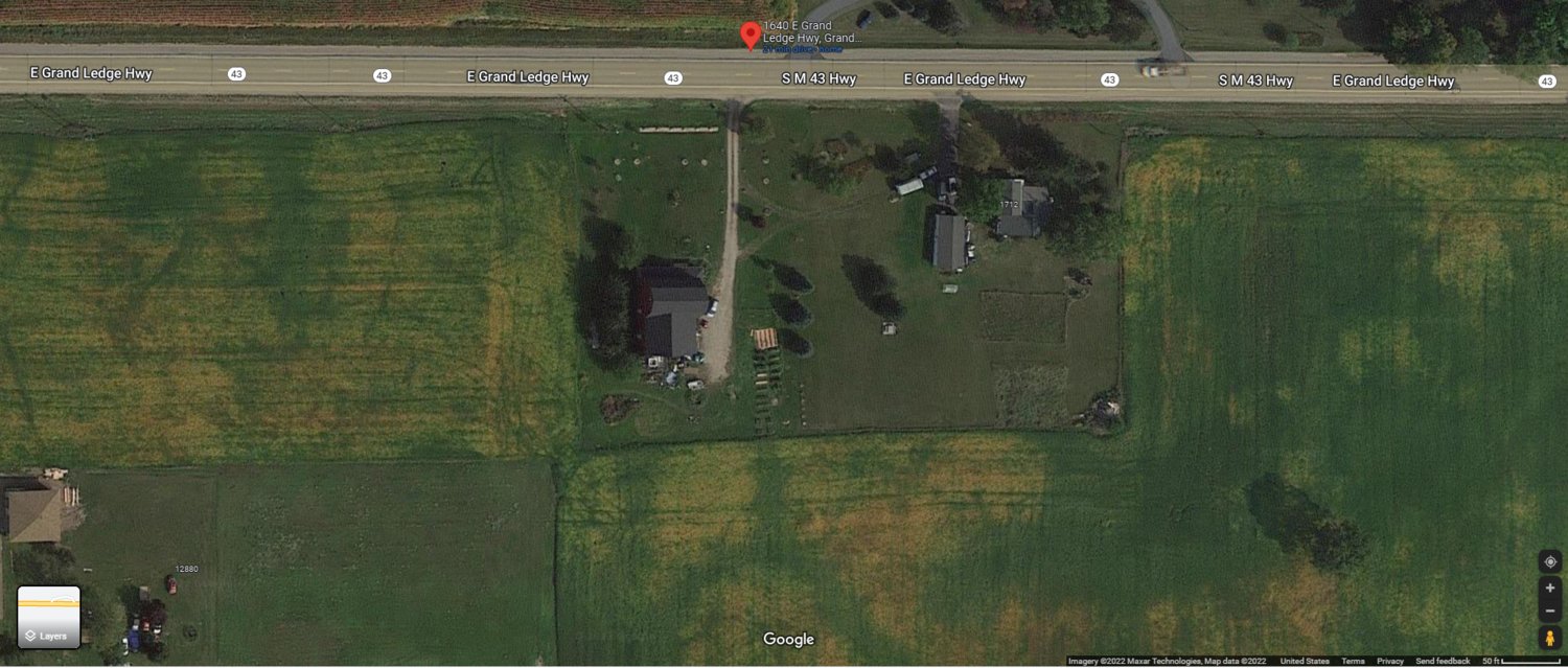 A Google Satellite image showing the red barn house property from above. The home in question is in the center of the picture, below Grand Ledge Highway, with a two-track gravel driveway. The image was taken before murder victim Clinton Decker and his spouse, Chadrick Decker, planted the front yard with blueberry bushes. The barn itself was built in approximately 1865. It was originally combined as one property with the 19th century farmhouse on the right. A divorce led to the property’s separation into two parcels. The barn was converted into a residence, and those who have been inside say it had a large living room and an interior balcony. But for unknown reasons, the house also had a series of maze-like hallways with small hidden rooms. It was in one of these rooms that Decker had his secret sex dungeon.