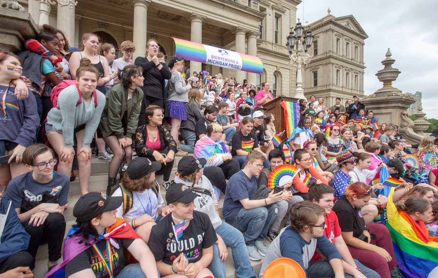 “LGBTQ…youth gather on the state Capitol steps during MI PRIDE rally in support of presenter Shane Shananaquet – Trans Teen and other youth concerns. 2019.”